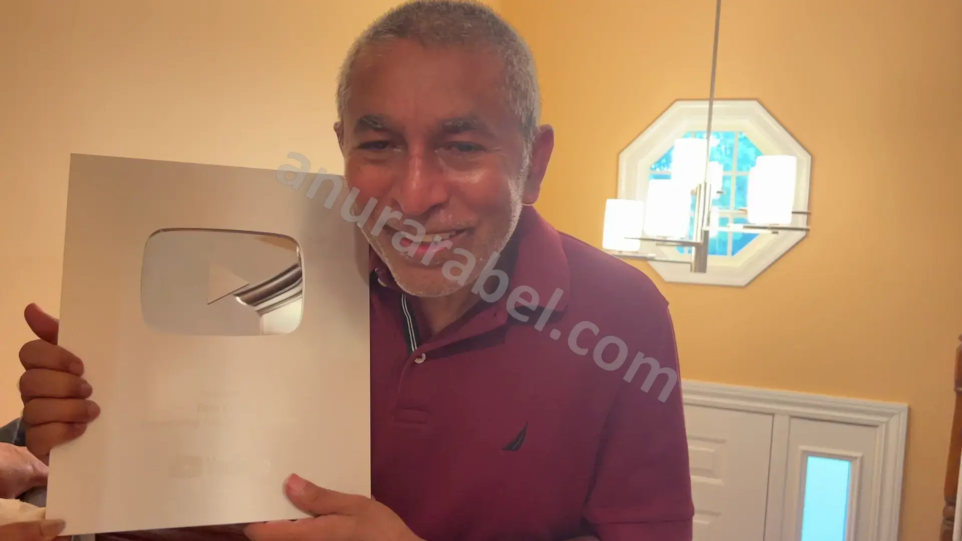 Anura holding the 100K Subscriber Silver Play Button Award from YouTube for Ruwanthi's Cooking Channel